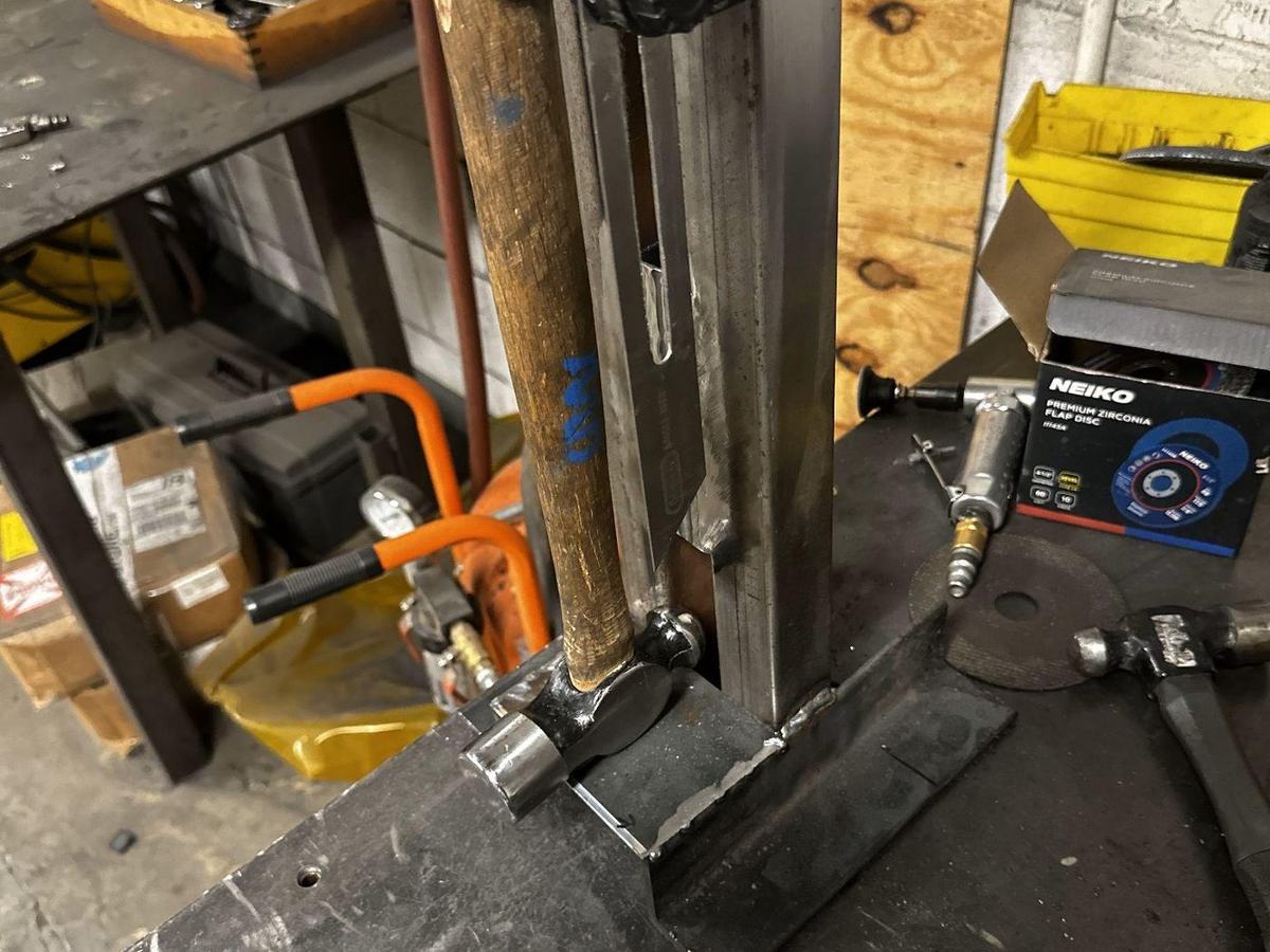Welded steel pendulum impact rig built to deliver repeatable strikes to composite test panels