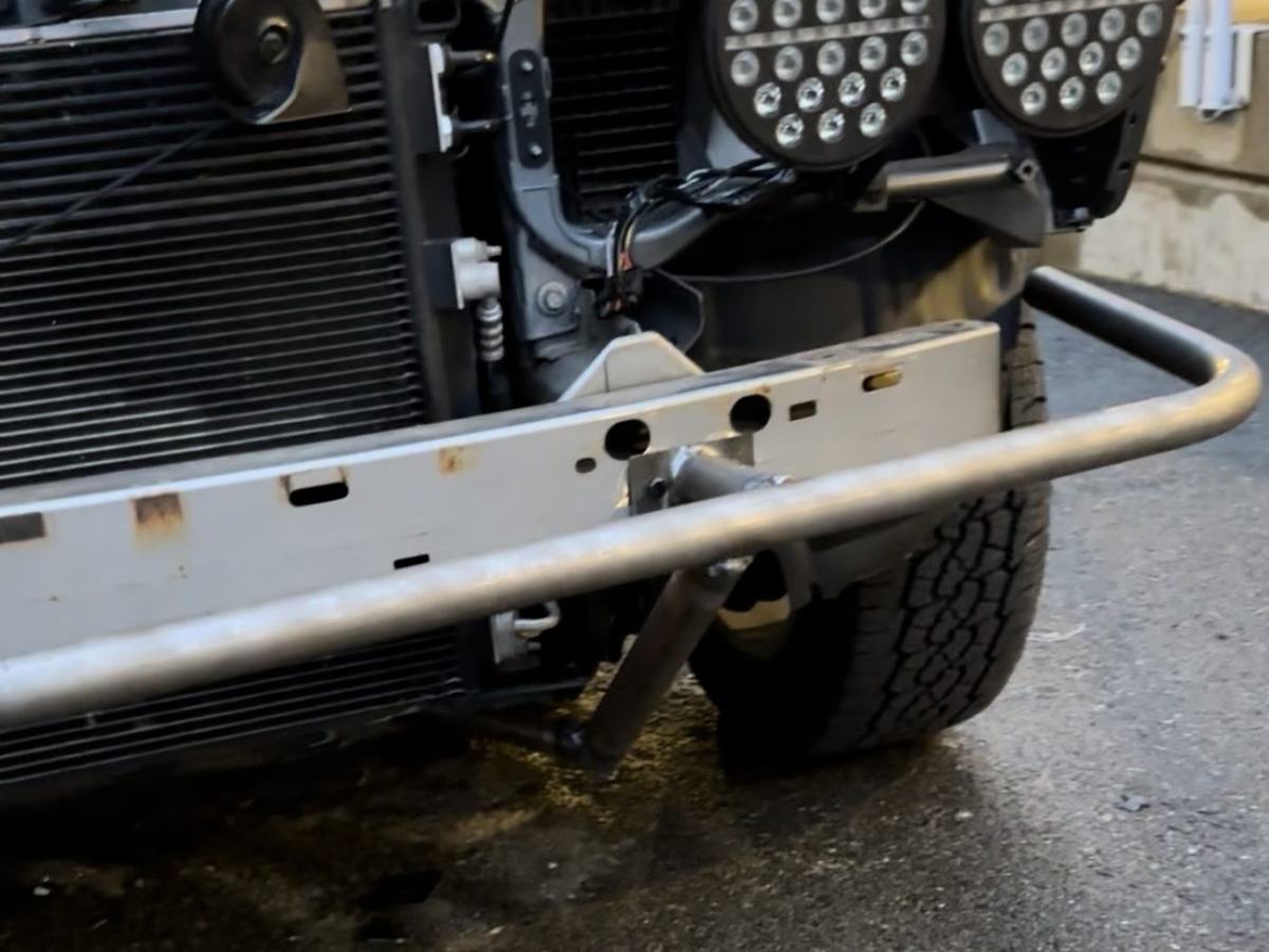Bumper structure mounted with the hood open, radiator and factory crash bar visible