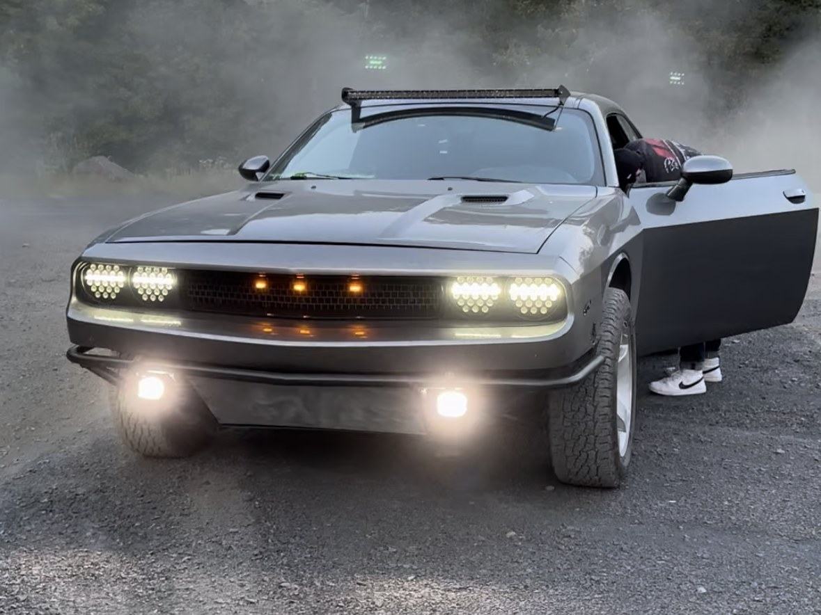The Challenger on a dirt road in a cloud of dust