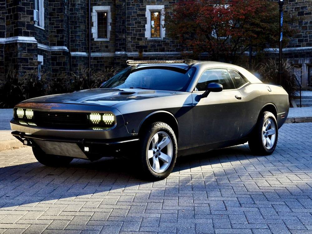 The completed Challenger off-road build, front three-quarter view with lights on