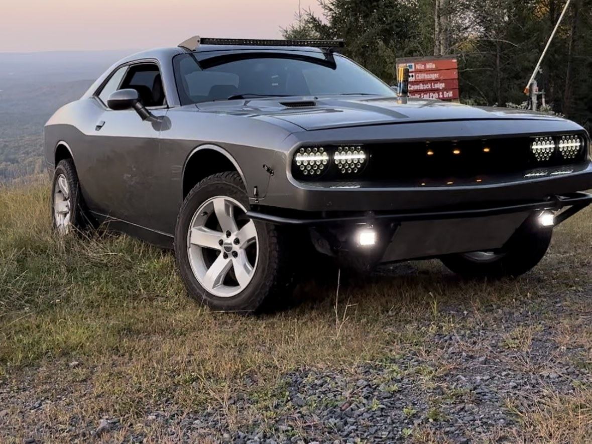 The Challenger parked on gravel at a mountain overlook at sunset