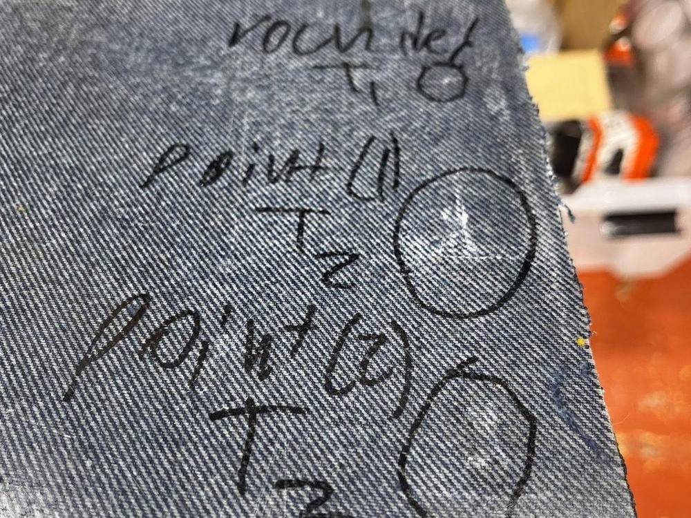 Denim panel marked with numbered impact points and round counts