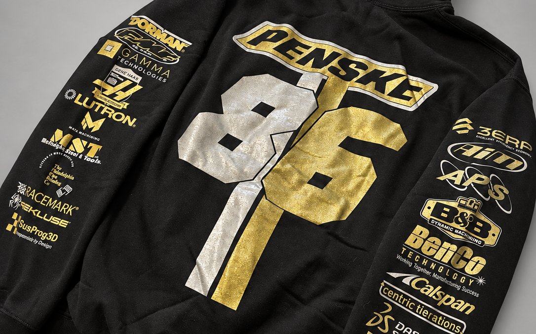 Team race hoodie in the black and gold identity, sponsor marks on the sleeves