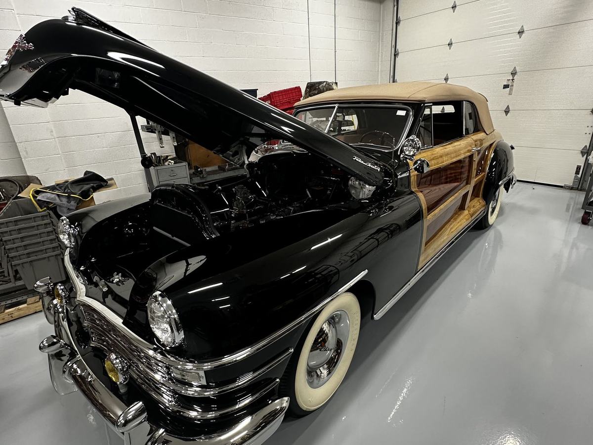 Woody wagon in the shop with the hood raised for engine work