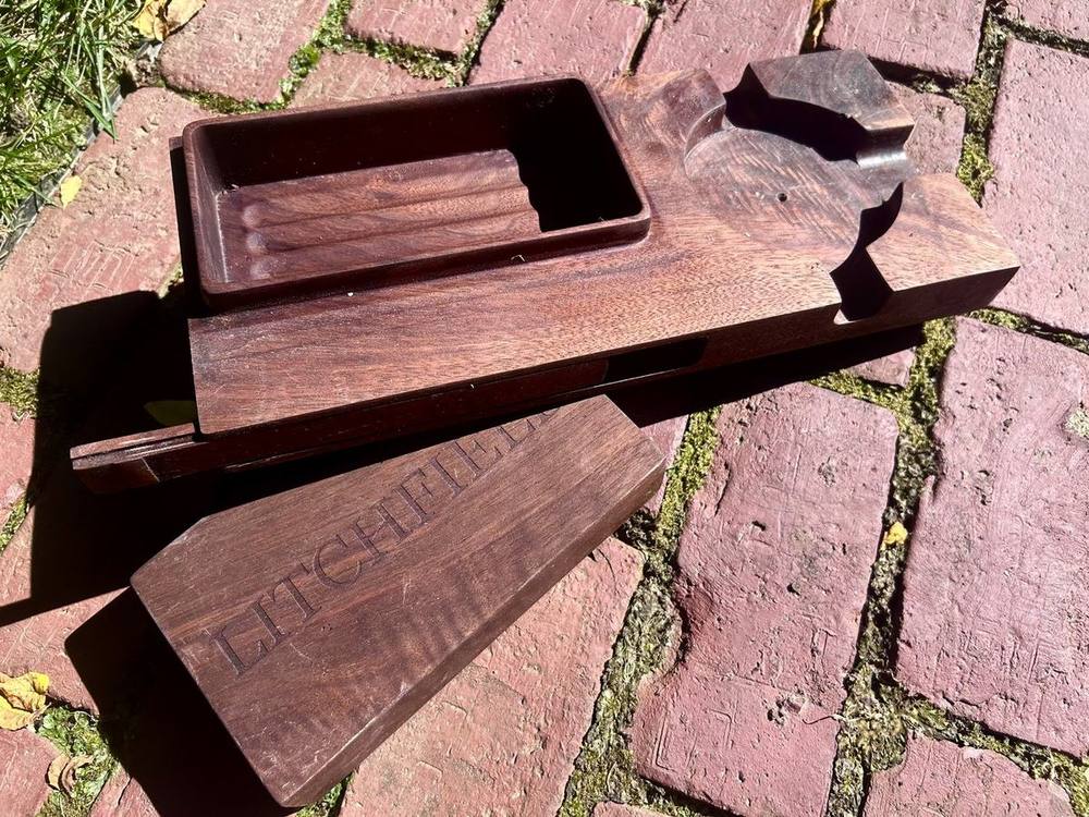 Cigar box open with the engraved sliding lid removed, showing the milled pockets